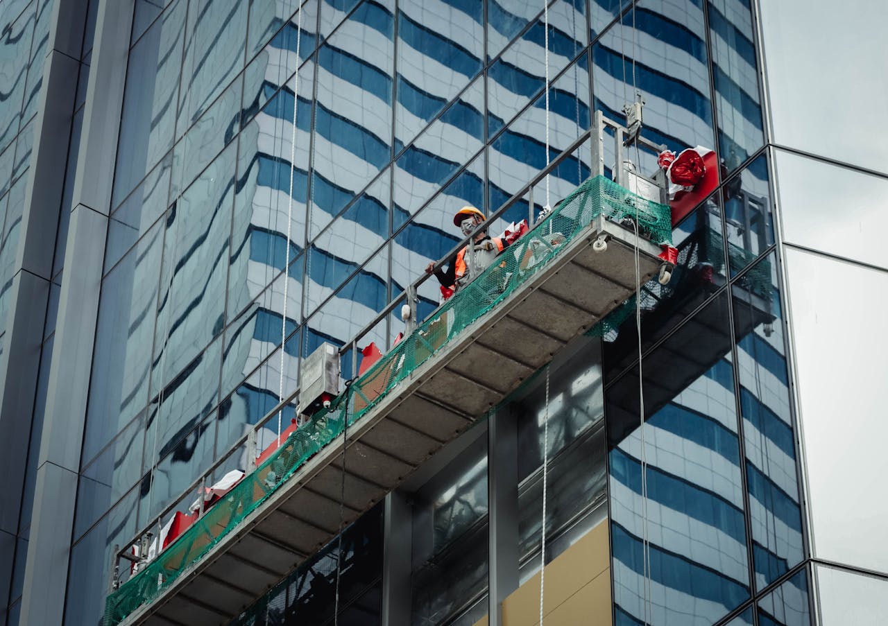 Urban worker cleaning windows on a high-rise in Ho Chi Minh City, Vietnam.